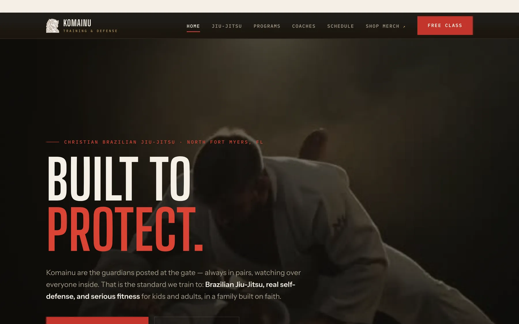 The Komainu Training & Defense home page — “Built to protect” in tall white and red type over a dimly lit photo of two people grappling on the mat, with a red Free class button in the header.